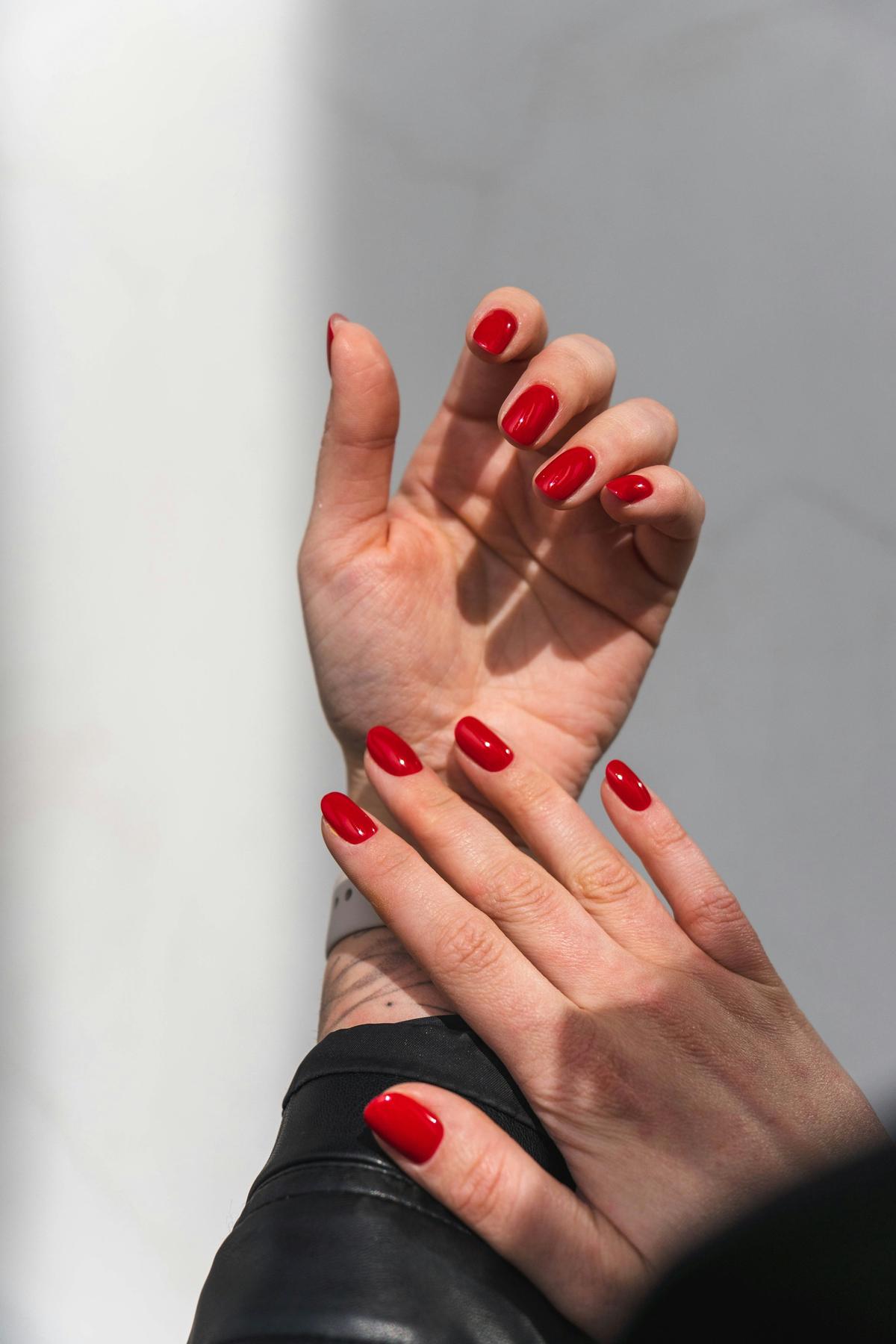Twee handen met rode gelnagels